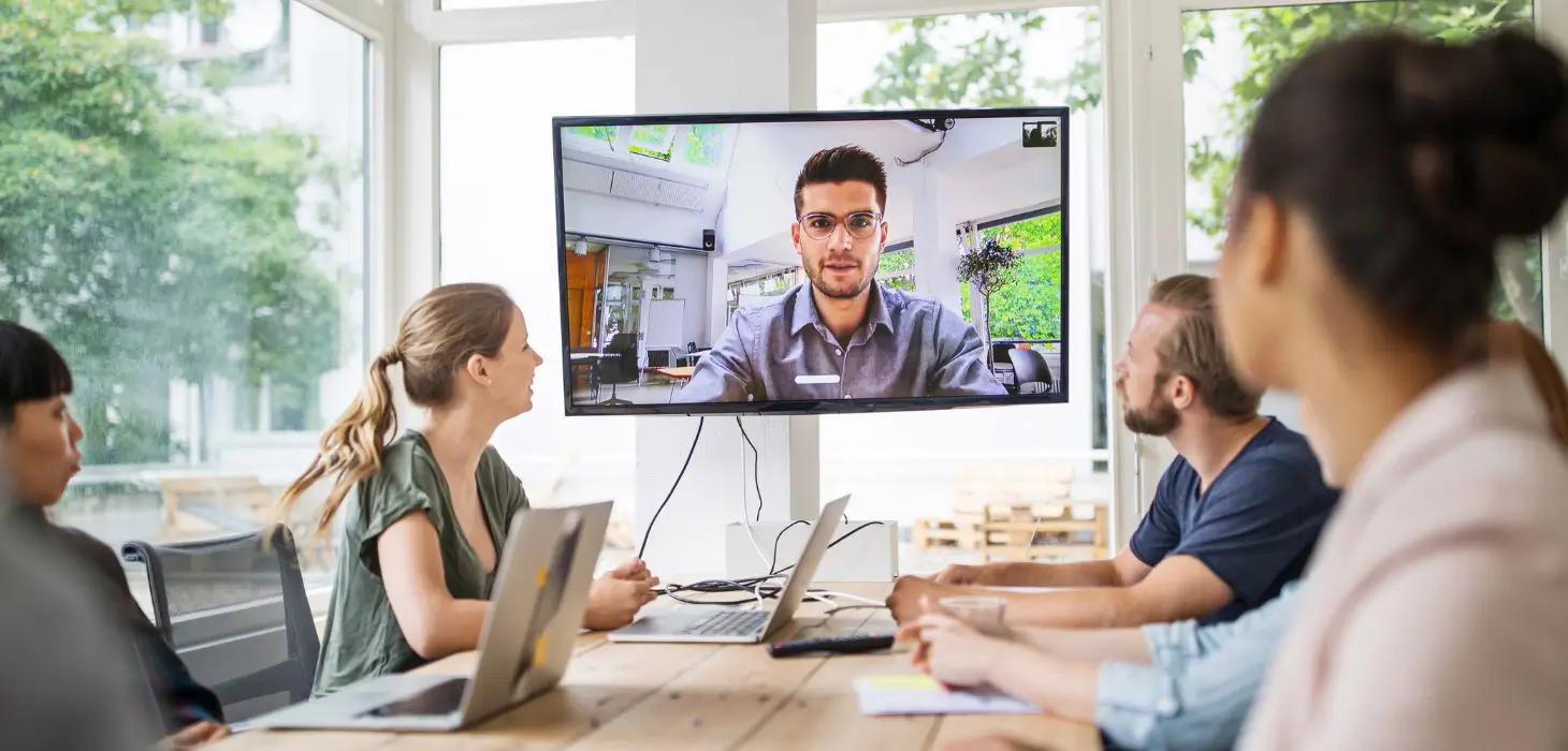 5 people in a meeting and one virtually presumably via hybrid workplace