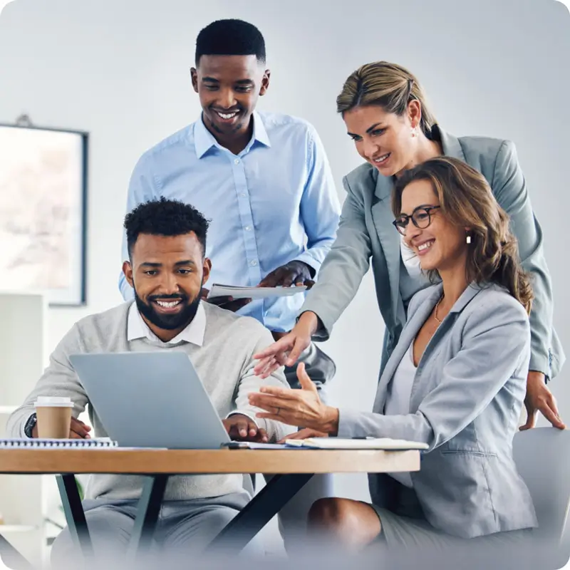 4 people in a meeting referring to a laptop